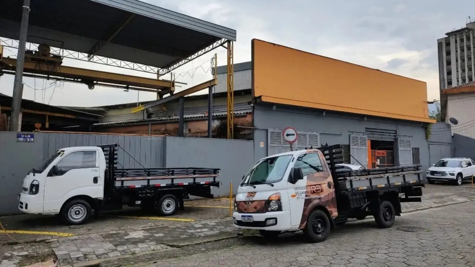 Base operacional da R3 Usinagem em Cubatão/SP, com caminhões e pátio da empresa